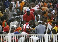 Supporters carry an injured person at Felix Houphouet-Boigny stadium during a 2010 World C