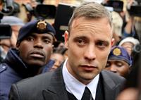 Olympic and Paralympic track star Oscar Pistorius leaves court after appearing for the 201