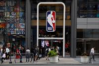 The NBA logo is displayed as people pass by the NBA Store in New York